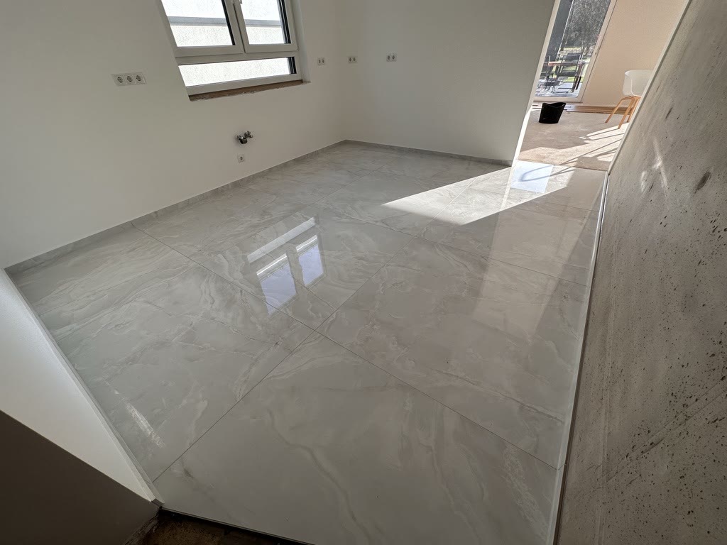 Großformatige Bodenfliesen in Marmoroptik in einem realisierten Wohnprojekt