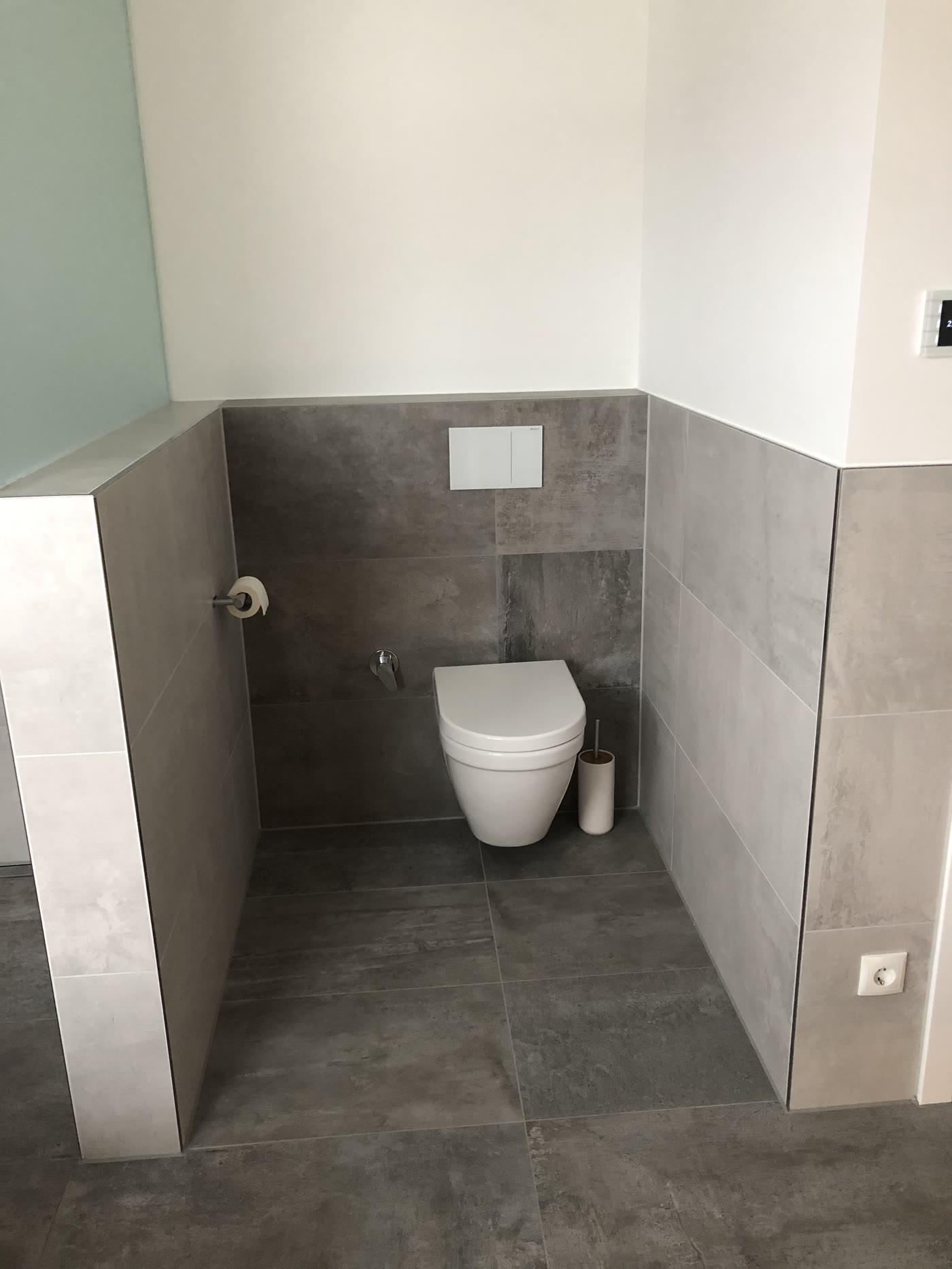 Gäste-WC mit halbhoch verlegten grauen Fliesen