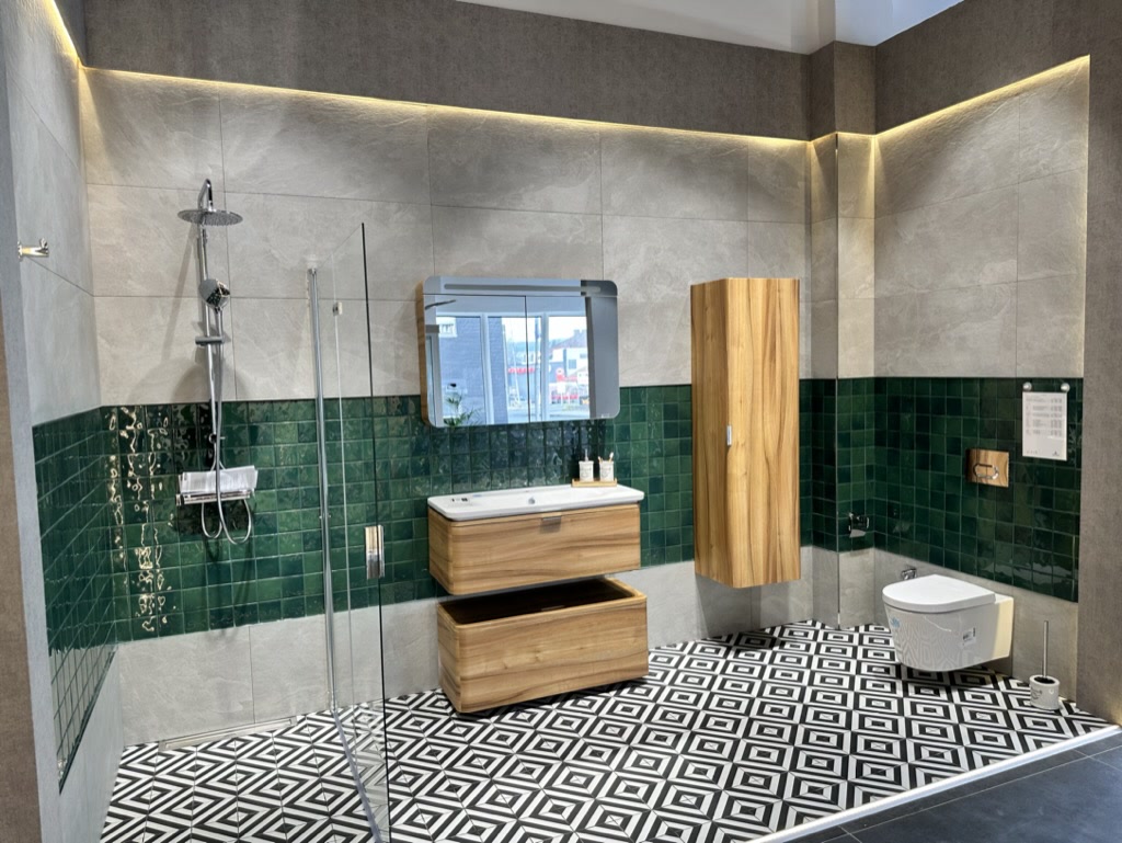 Badkoje mit grünen Fliesen und Holzmöbeln im tentia Showroom