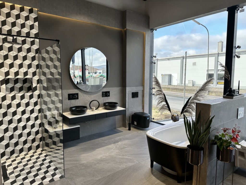 Schwarz-weiße Badwelt mit freistehender Badewanne im tentia Showroom